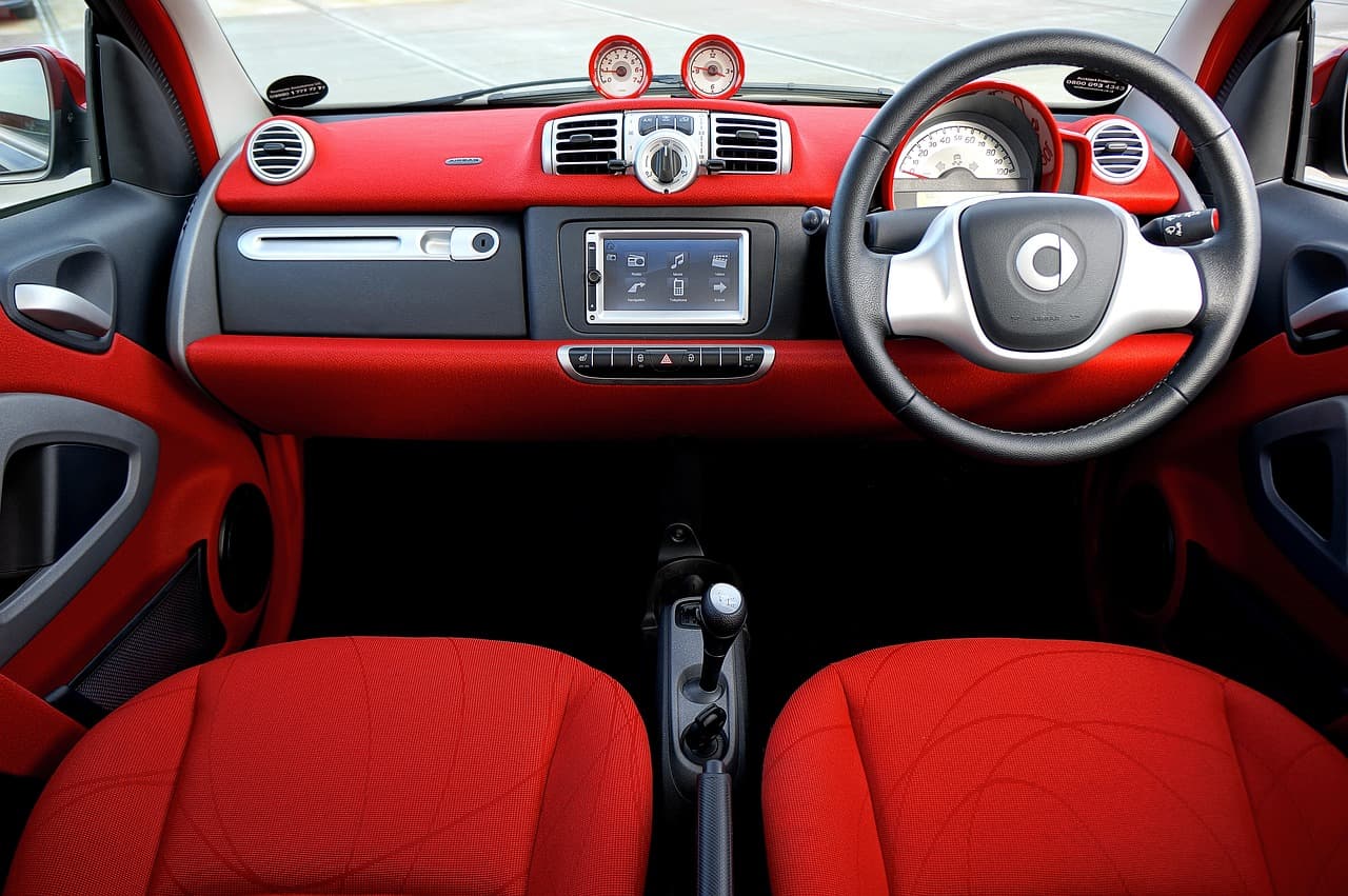 Red suede car seats and dashboard in a modern compact vehicle interior.