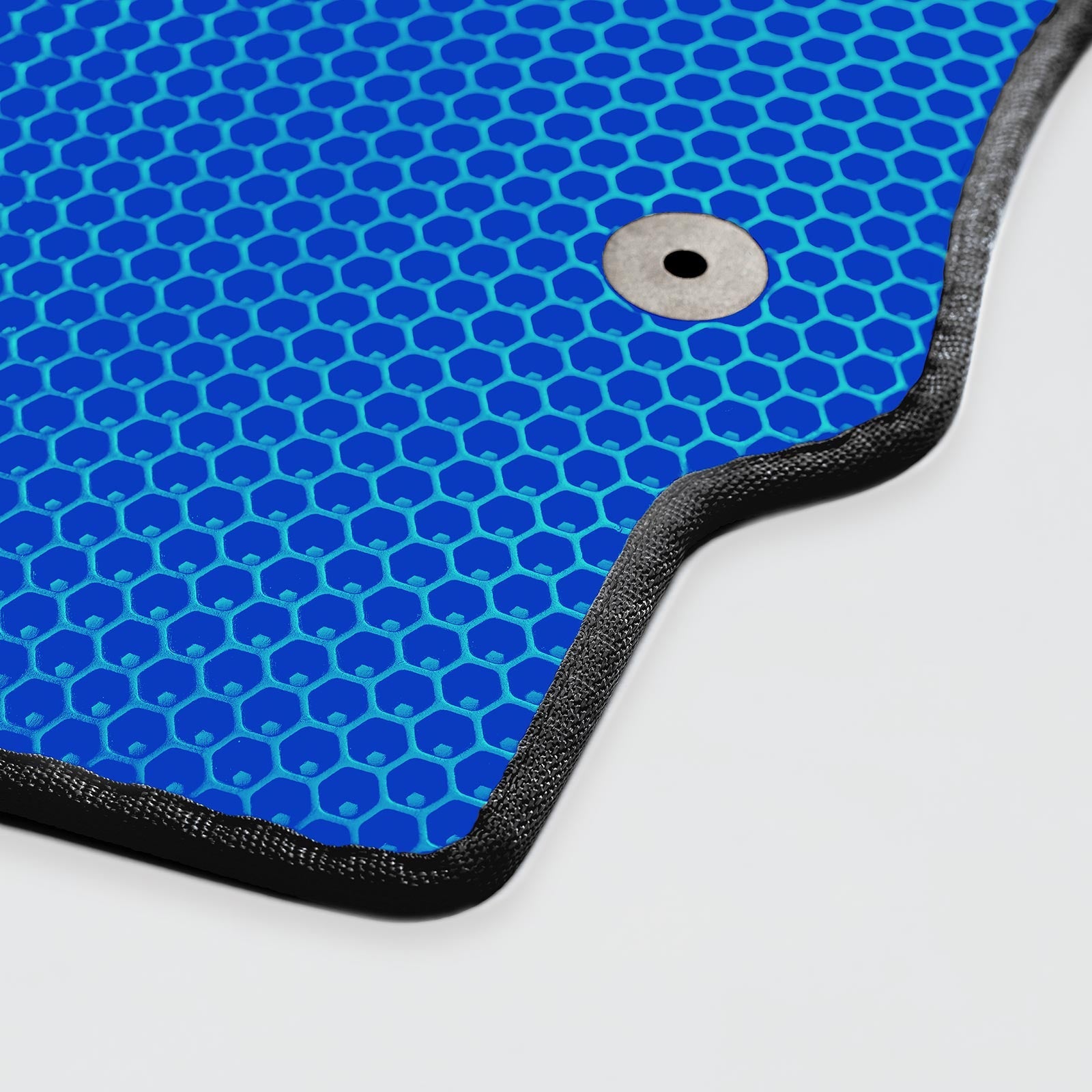 Close-up of a textured blue mat with a honeycomb pattern and a fastening hole.