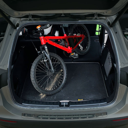 Red bike on black EVA mat in car trunk by Prime EVA.
