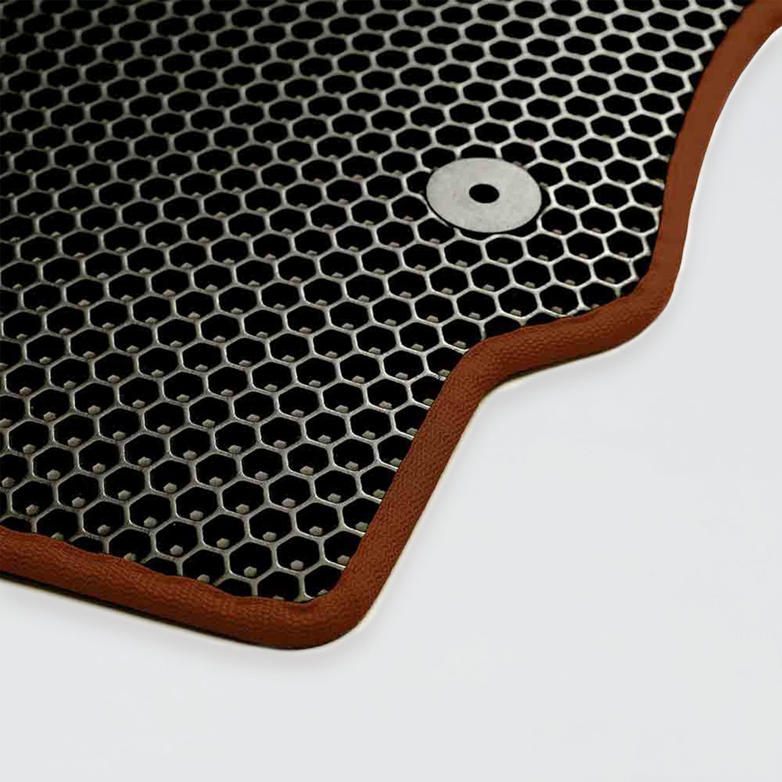 Textured black rubber car mat with hexagonal pattern and brown border