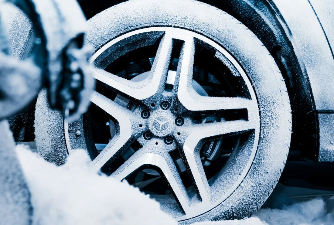 Close-up of car wheel covered with frost and snow during winter season.