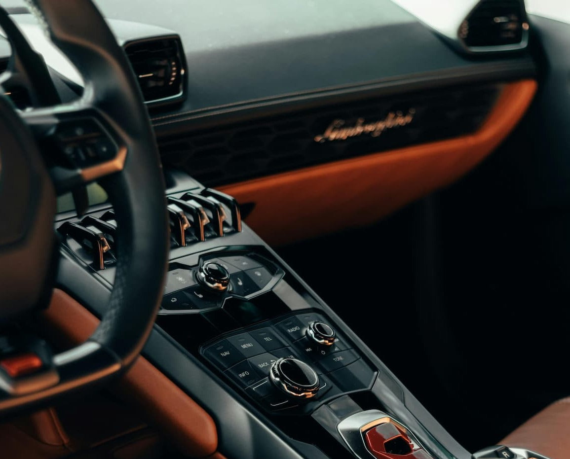 Luxury sports car interior with premium center console, drive controls, and leather trim details.