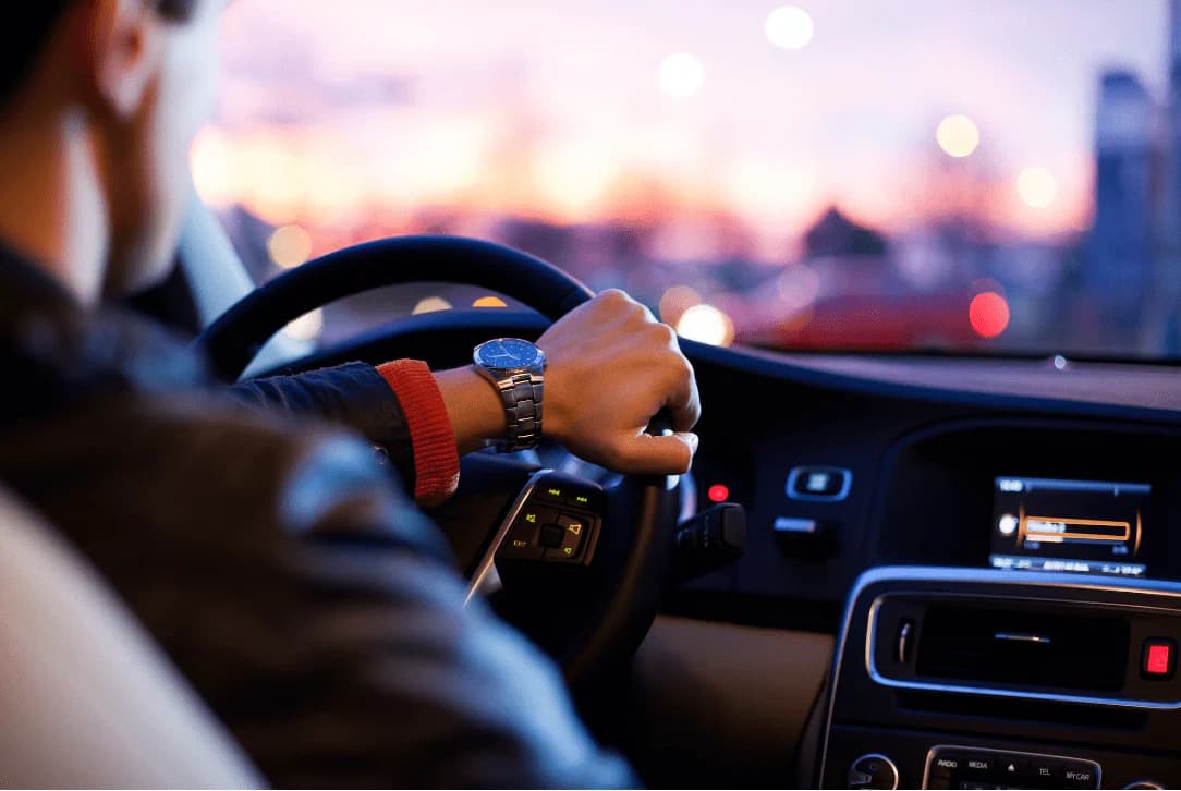 Man confidently driving a car along a scenic road