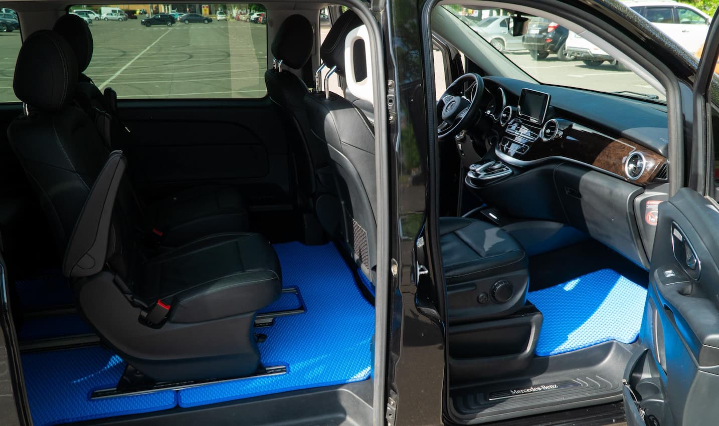 Blue EVA car floor mats installed in a black Mercedes van interior, covering front and middle rows.