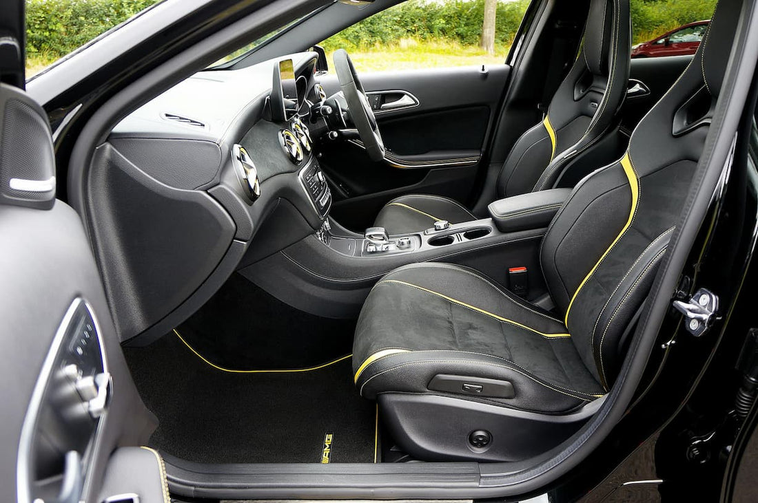 Premium sports car interior with bucket seats and custom floor mats fitted inside the vehicle.
