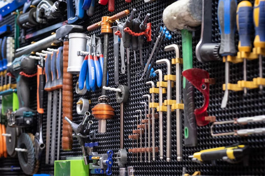 Organized tool storage panel in a garage with various hand tools and equipment neatly arranged.