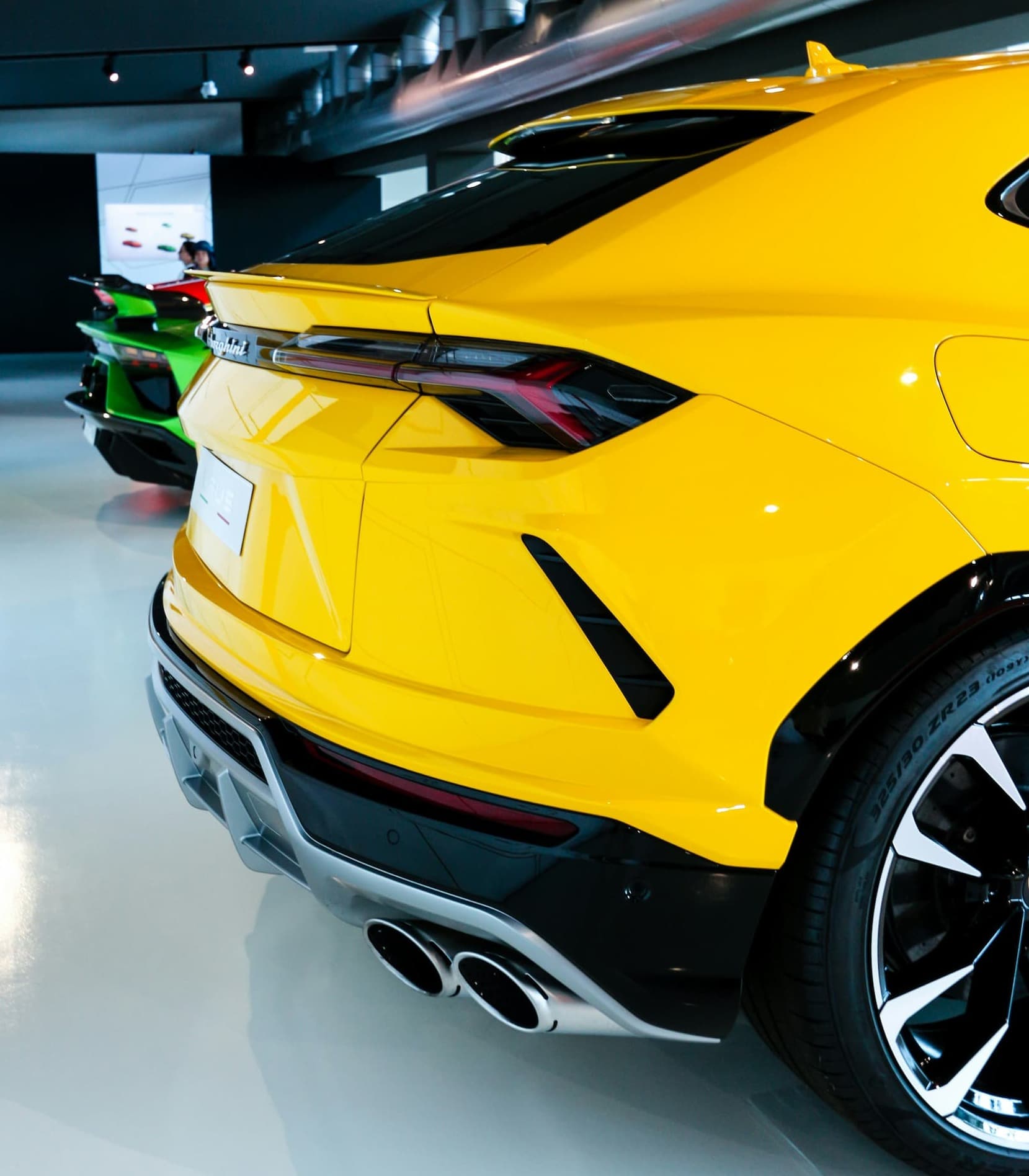 Rear view of yellow luxury SUV parked in modern showroom.