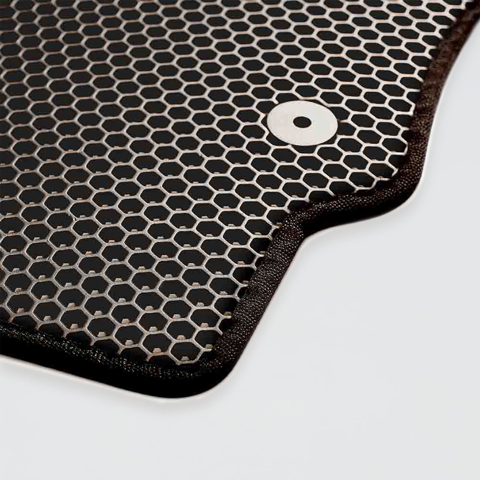 Close-up of a black honeycomb-patterned material with a metal button.