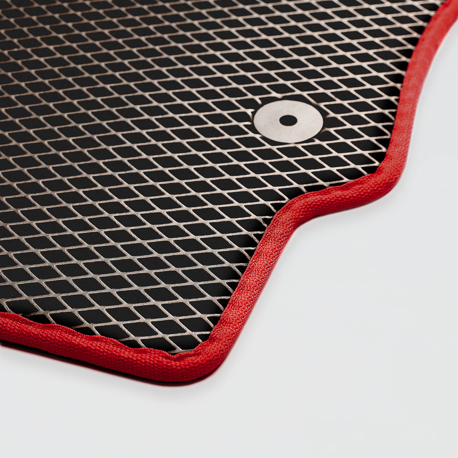 Close-up of a black mat with a red border and a circular metal button.