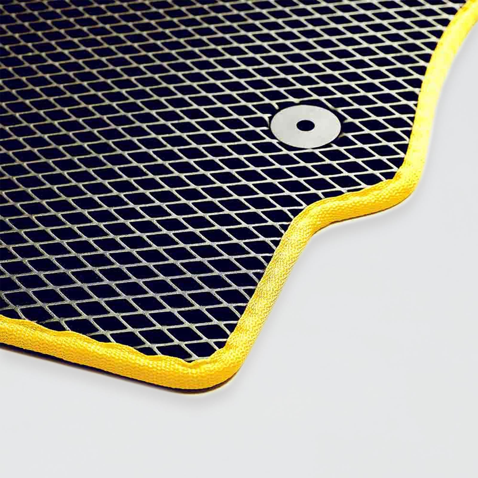 Black mesh mat with yellow trim and a circular button in the corner