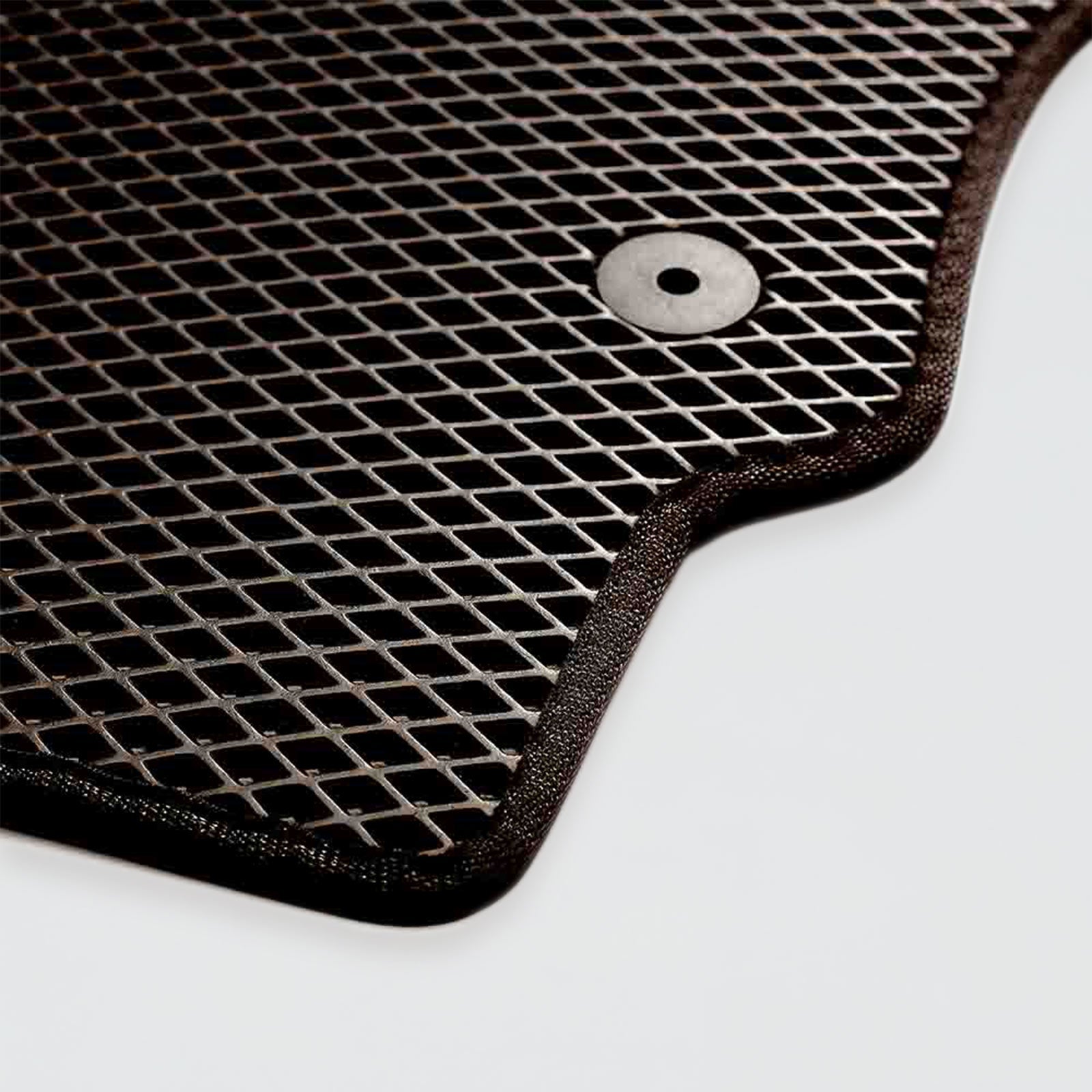 Black rubber car mat with a textured grid pattern and a metal eyelet.