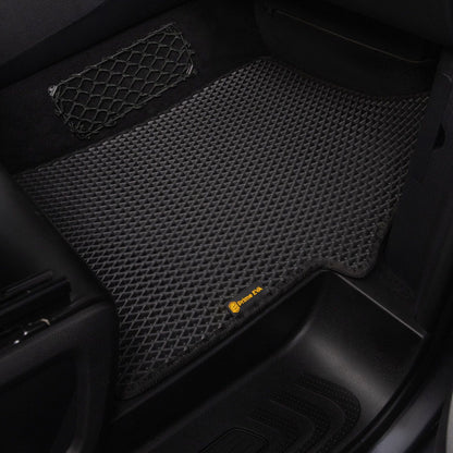 Black textured car floor mat in a passenger seat area, designed for durability.