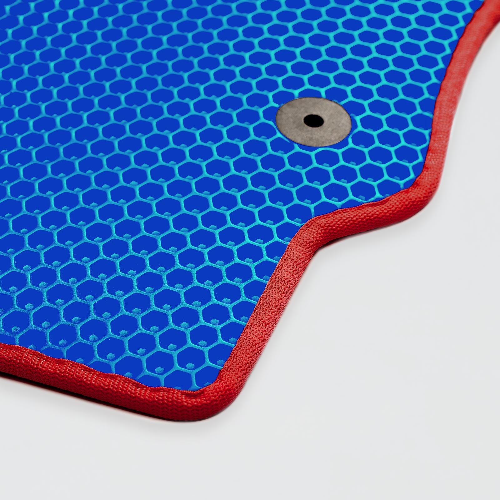 Blue hexagon-patterned mat with a red border and metal grommet.