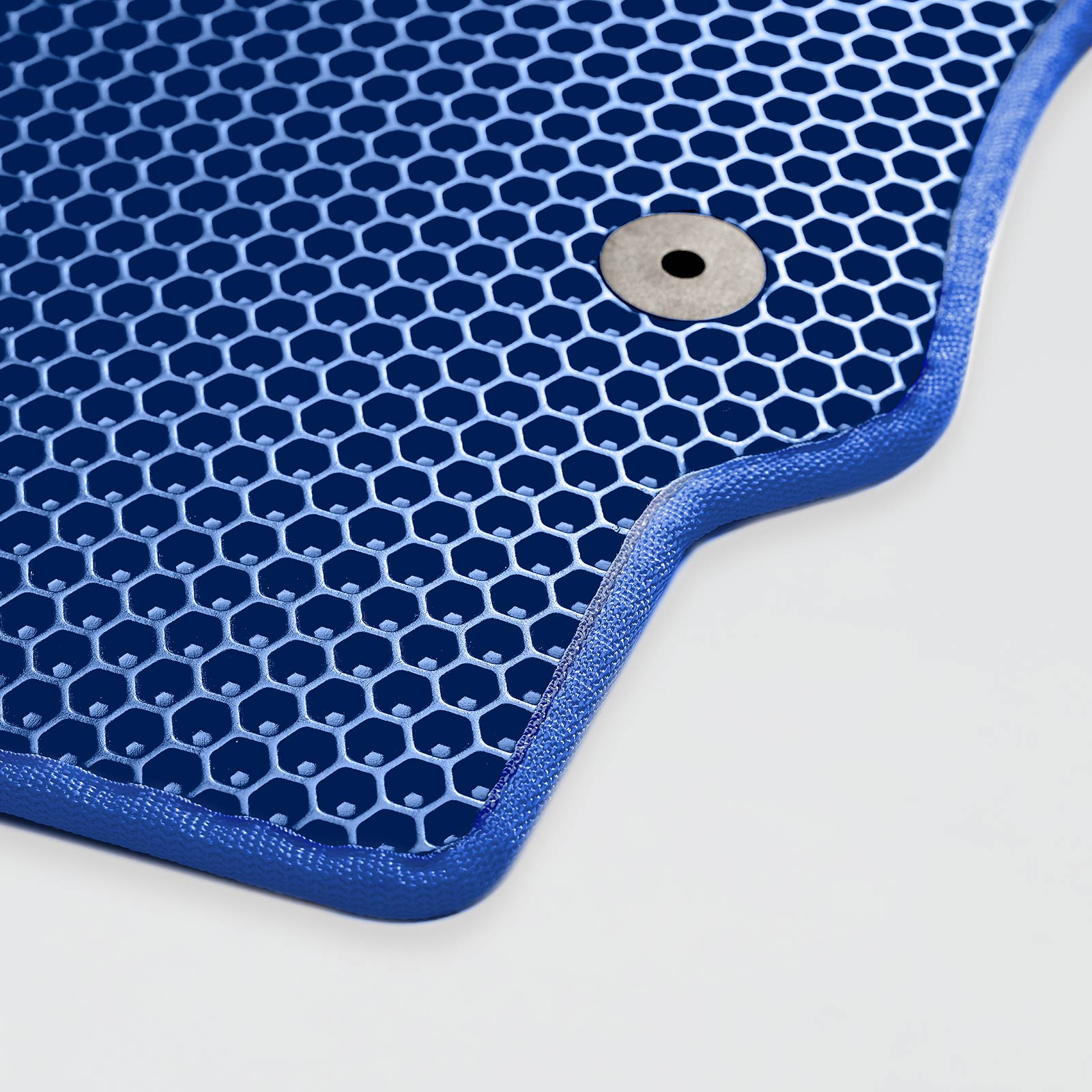 Close-up of a blue, hexagonal-patterned mat with a round metal fastener.