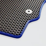 Close-up of a blue edge hexagonal mesh mat with a silver grommet.