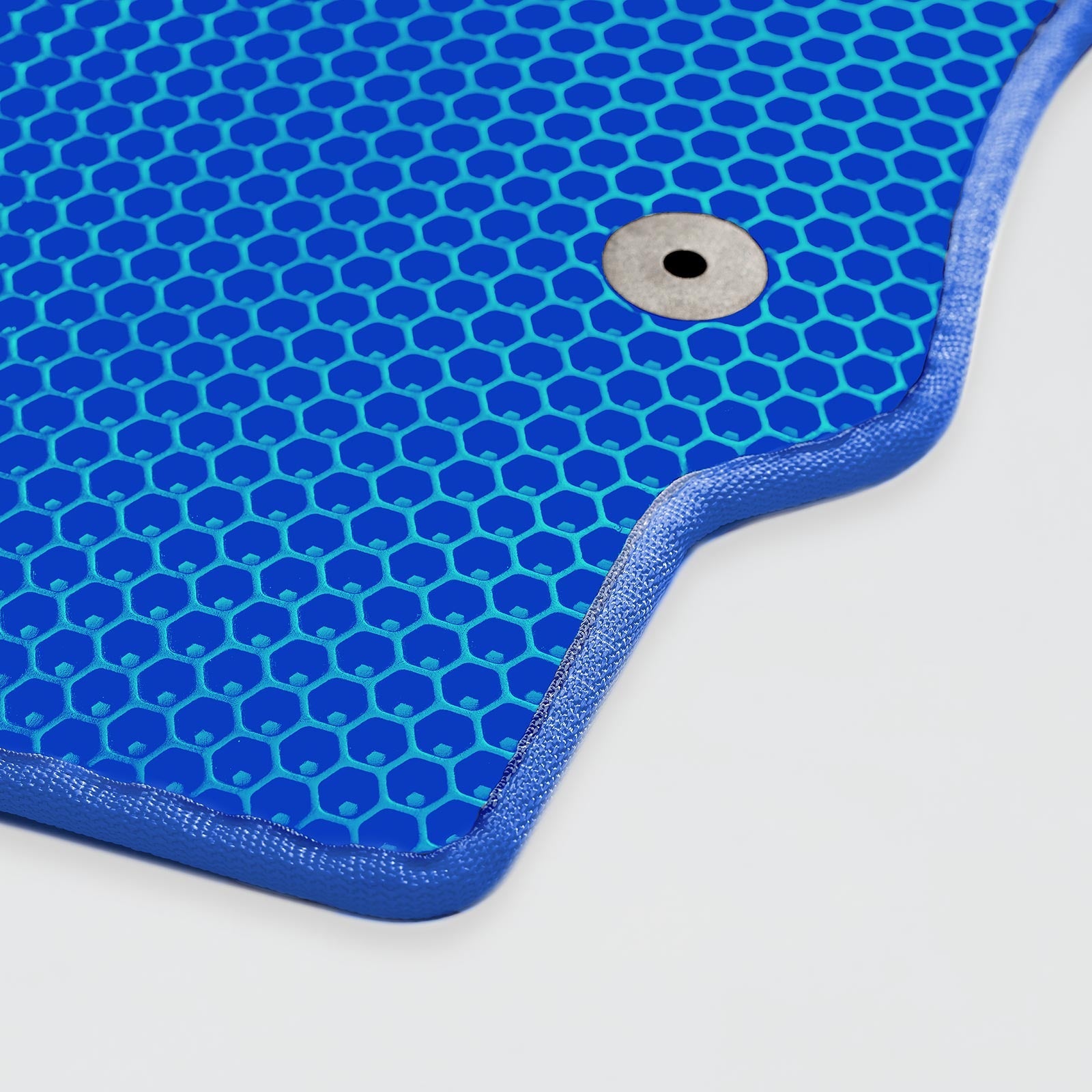 Blue honeycomb-patterned mat with a metallic grommet in one corner.
