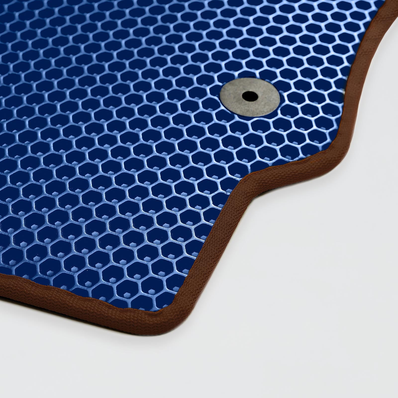 Blue honeycomb-patterned mat with brown edging and a circular grommet detail