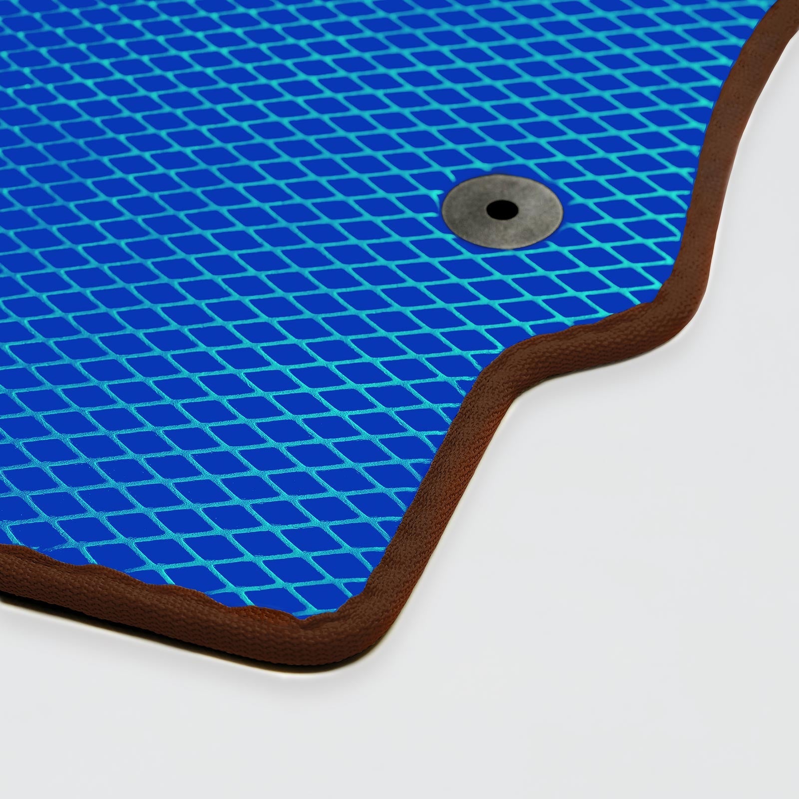 Close-up of a blue textured mat with brown edges and a metal grommet.