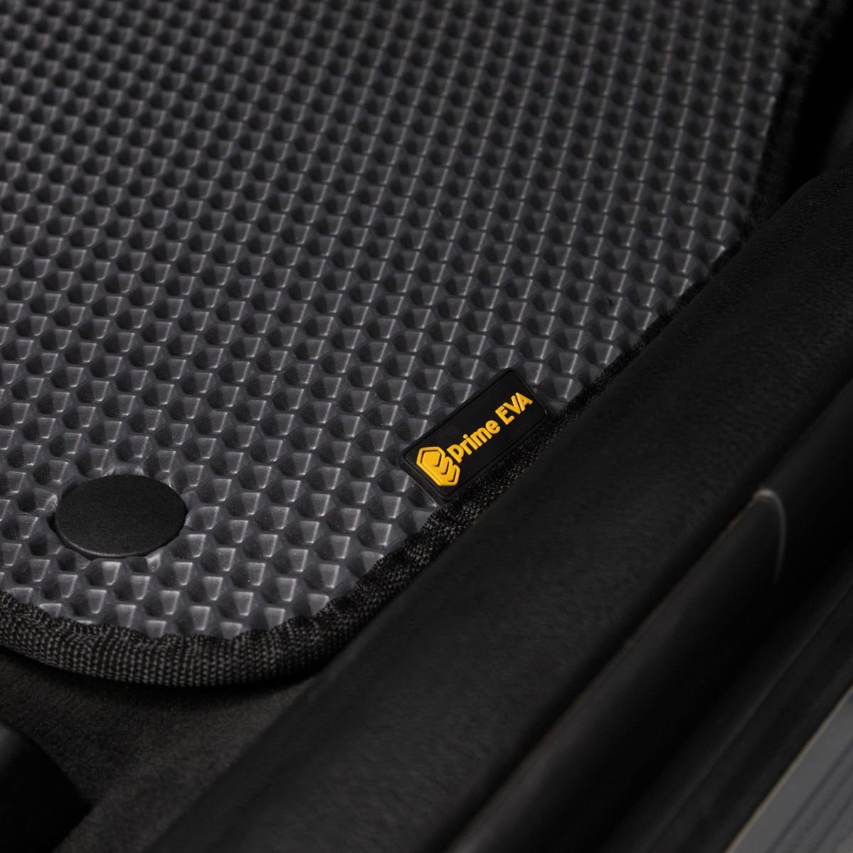 Close-up of a textured black car mat with Prime EVA logo, designed for BMW.