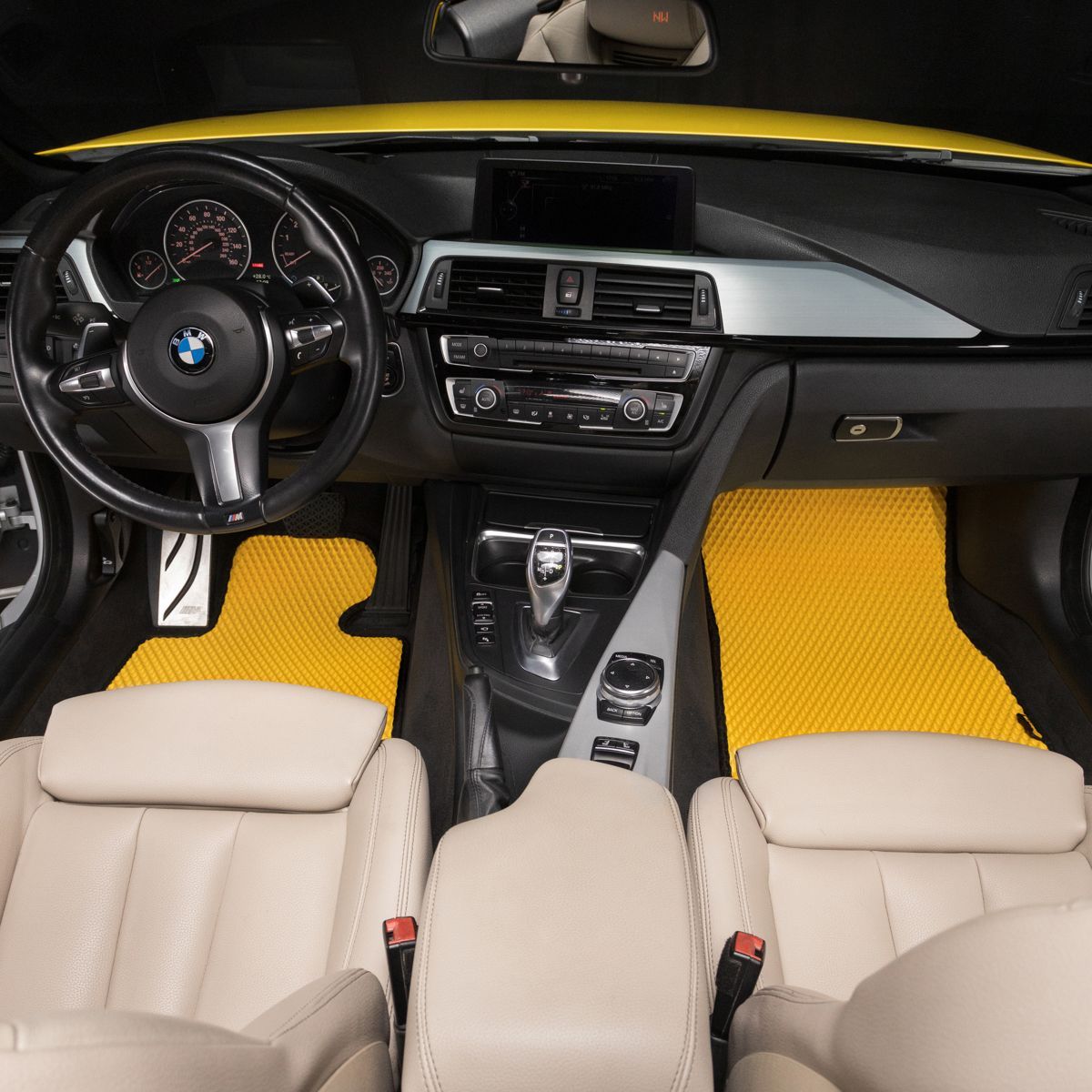 Yellow car floor mats custom-fitted for BMW interior, matching luxury design.