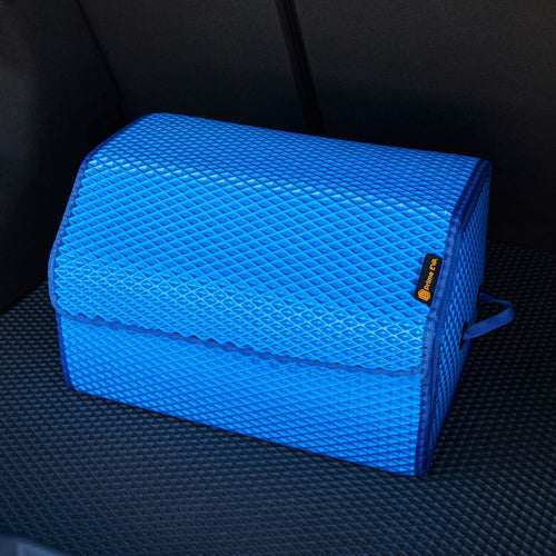 Didelis mėlynas automobilio bagažinės organizatorius ant juodo kilimėlio, skirtas tvarkingai saugoti.