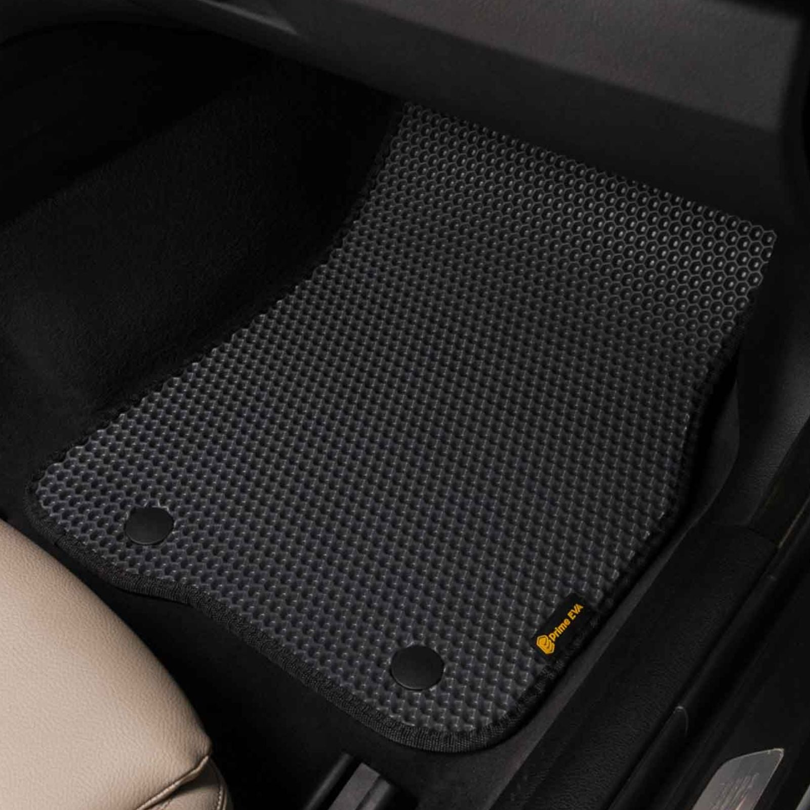 Close-up of a custom black passenger-side car floor mat installed in a car interior.