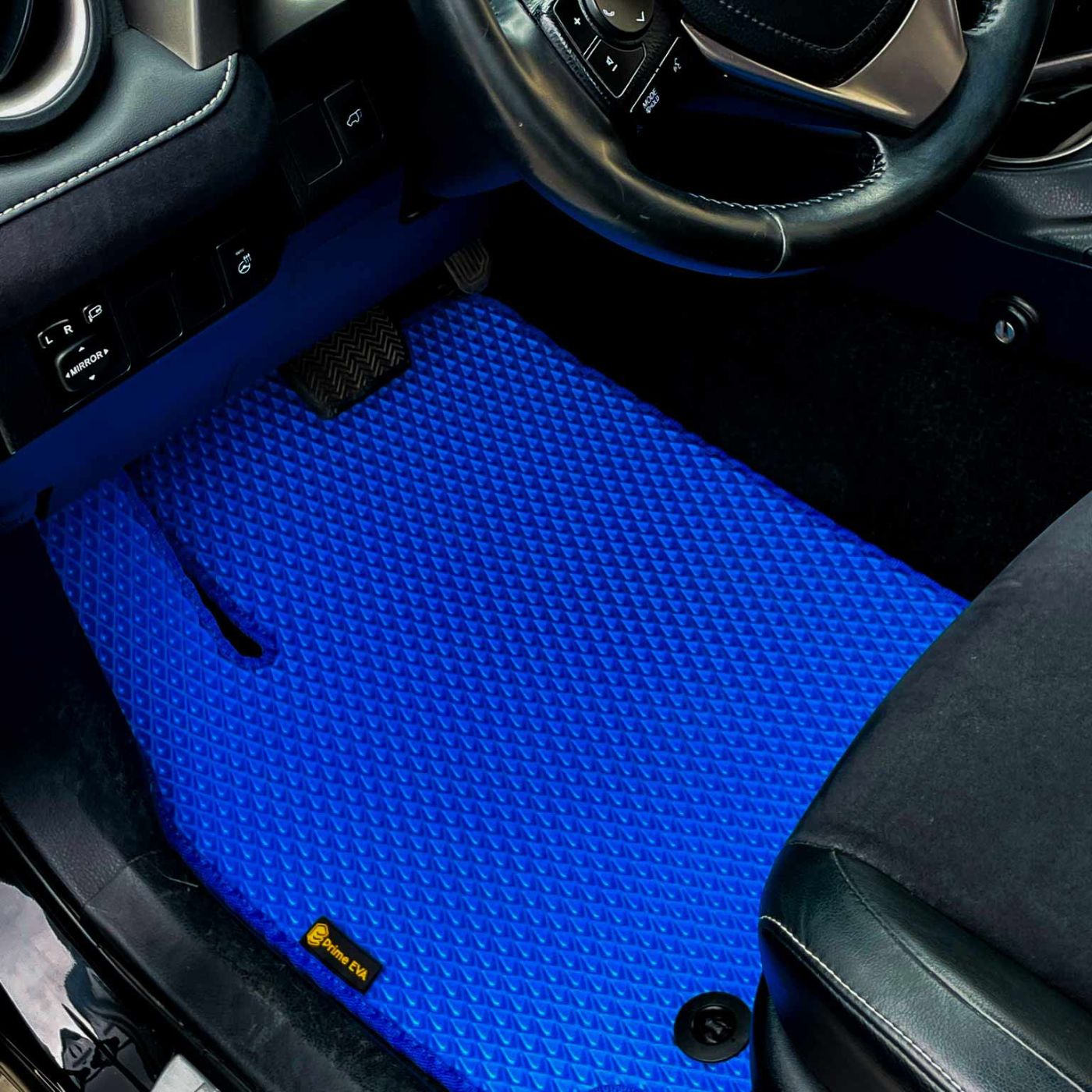 Close-up of a custom blue car floor mat installed in a Toyota interior.