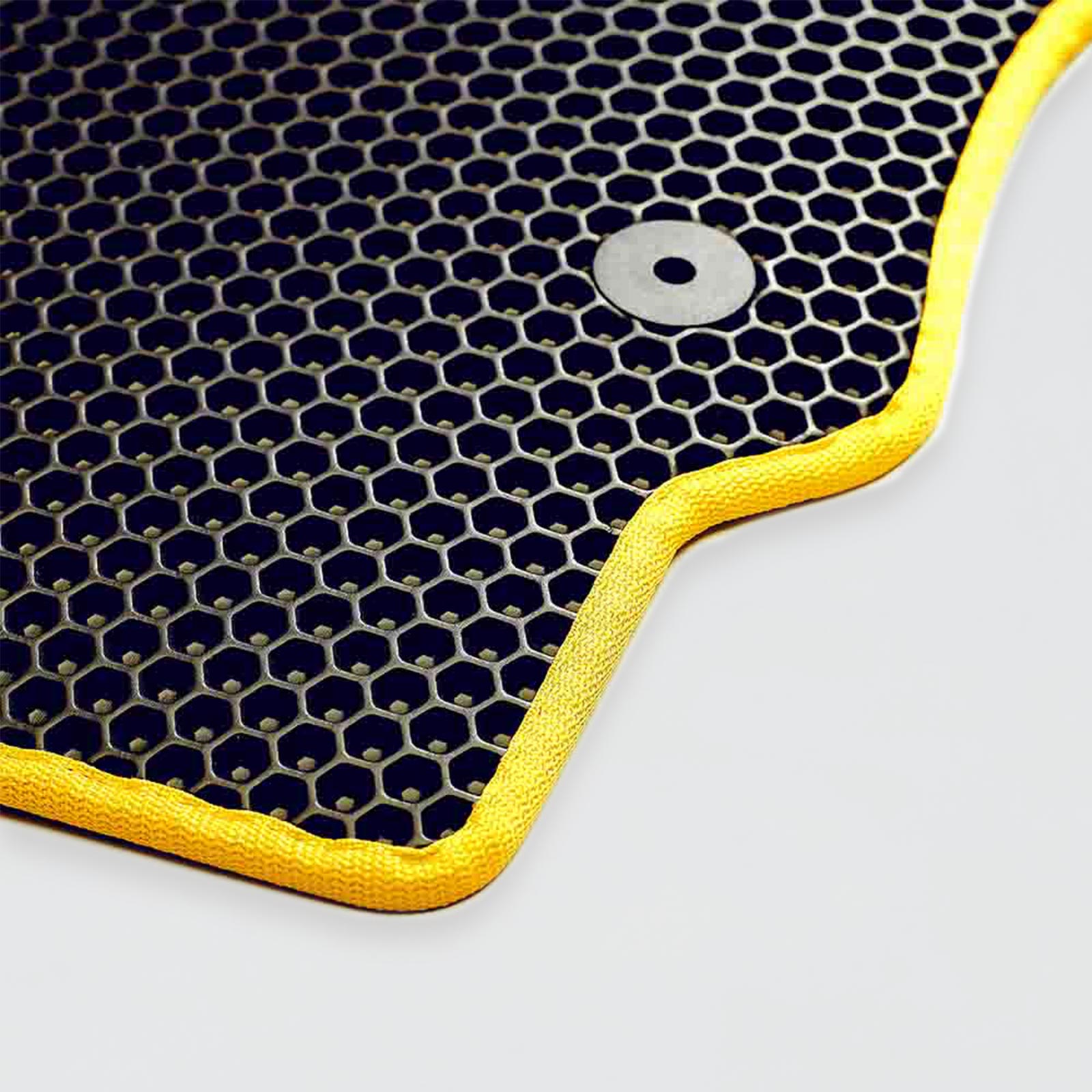 Black and yellow hexagonal-patterned rubber mat with a metal grommet.
