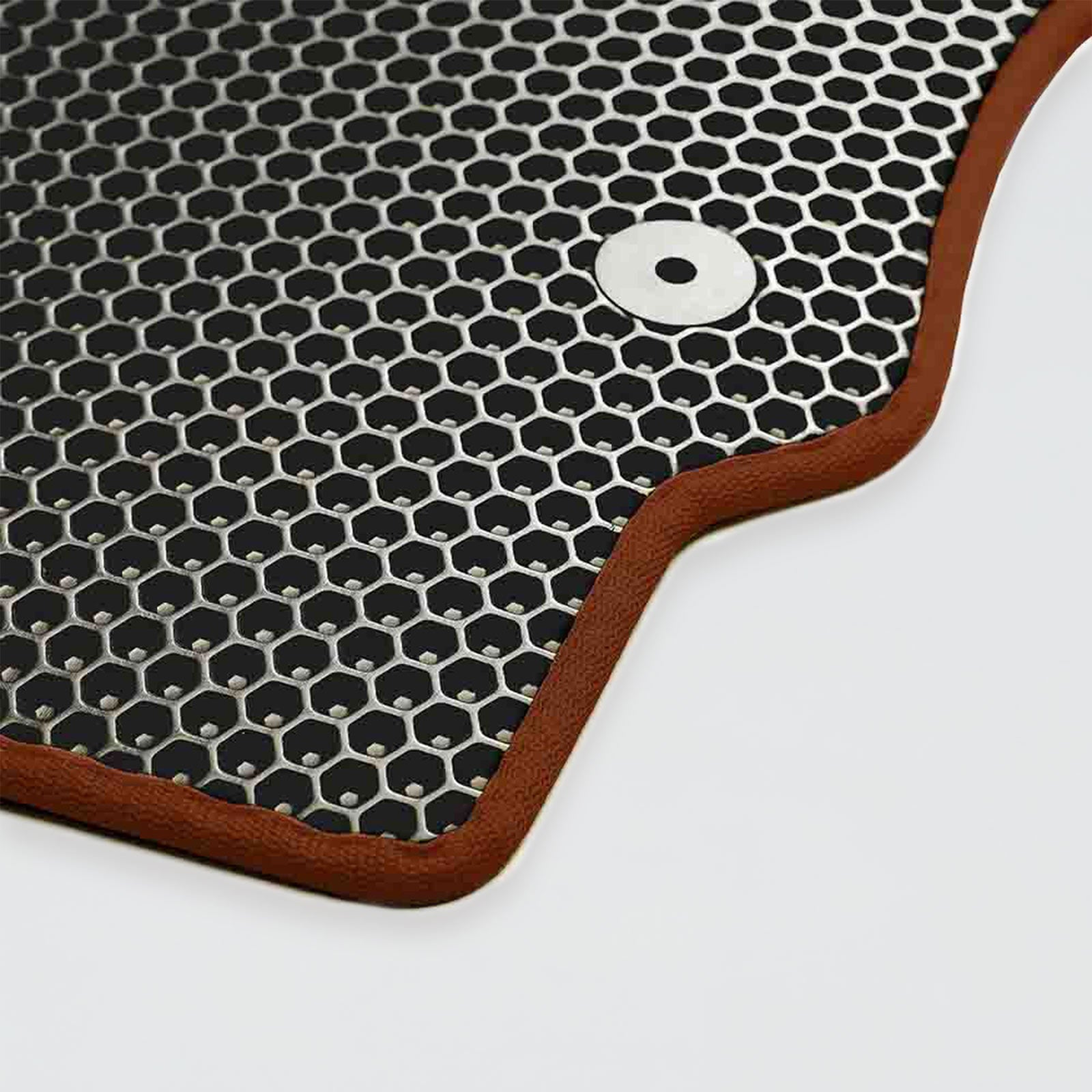 Textured black rubber mat with a honeycomb pattern and brown edge.