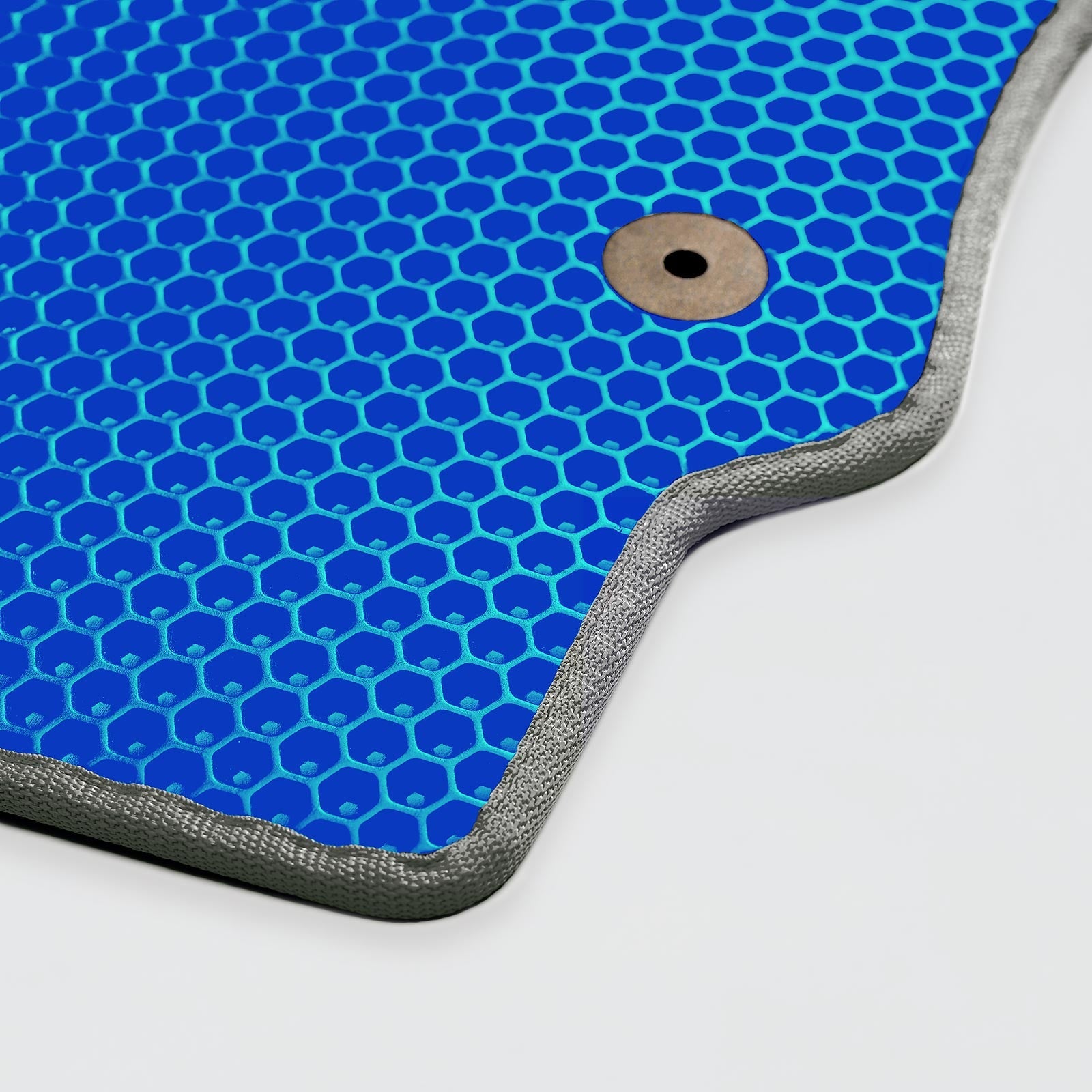 Blue honeycomb patterned mat with a silver edge and a dark circular hole.