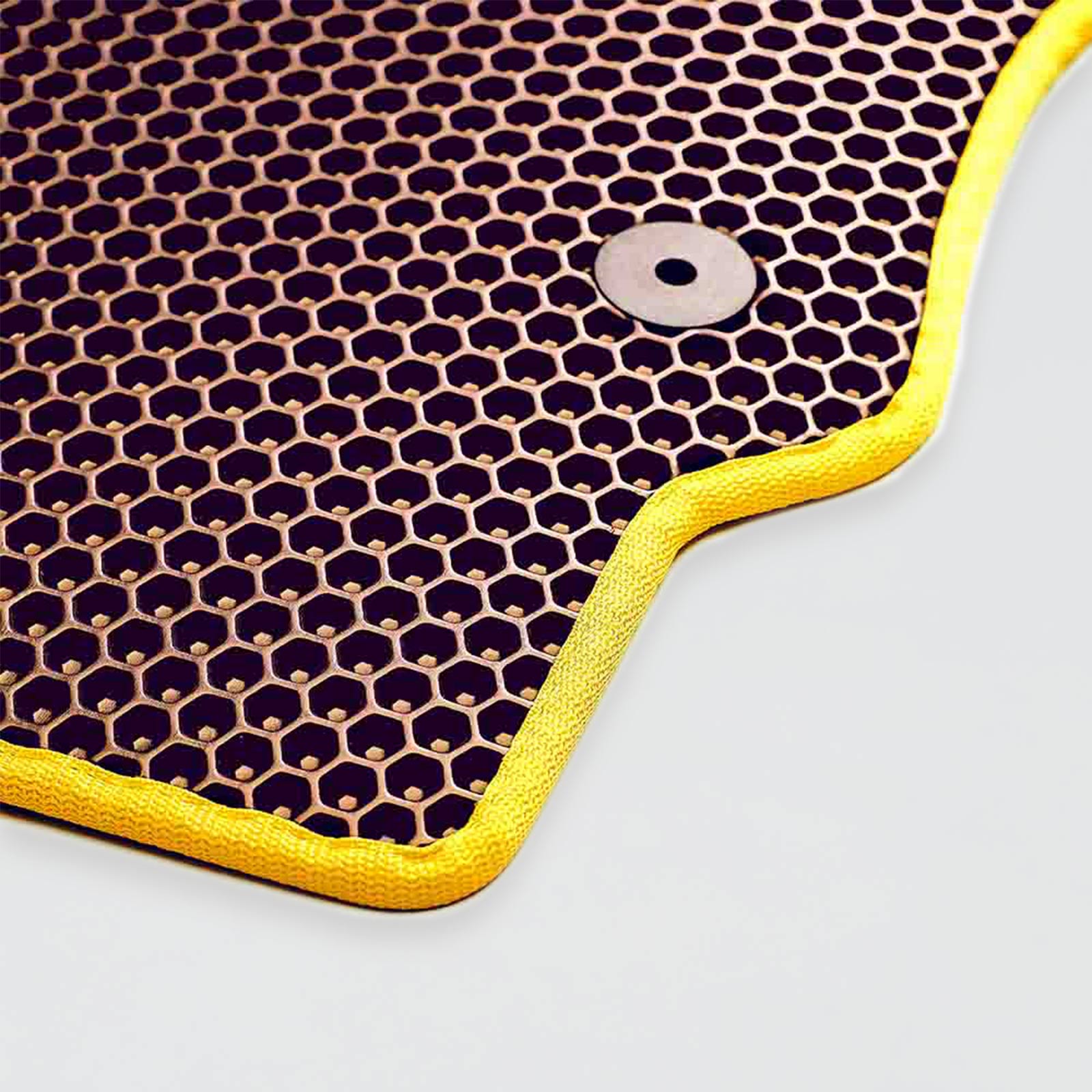 Honeycomb-patterned mat with a yellow border and a metallic fastener.