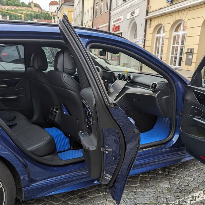 Blue car floor mats in a Mercedes-Benz, enhancing the stylish black interior.