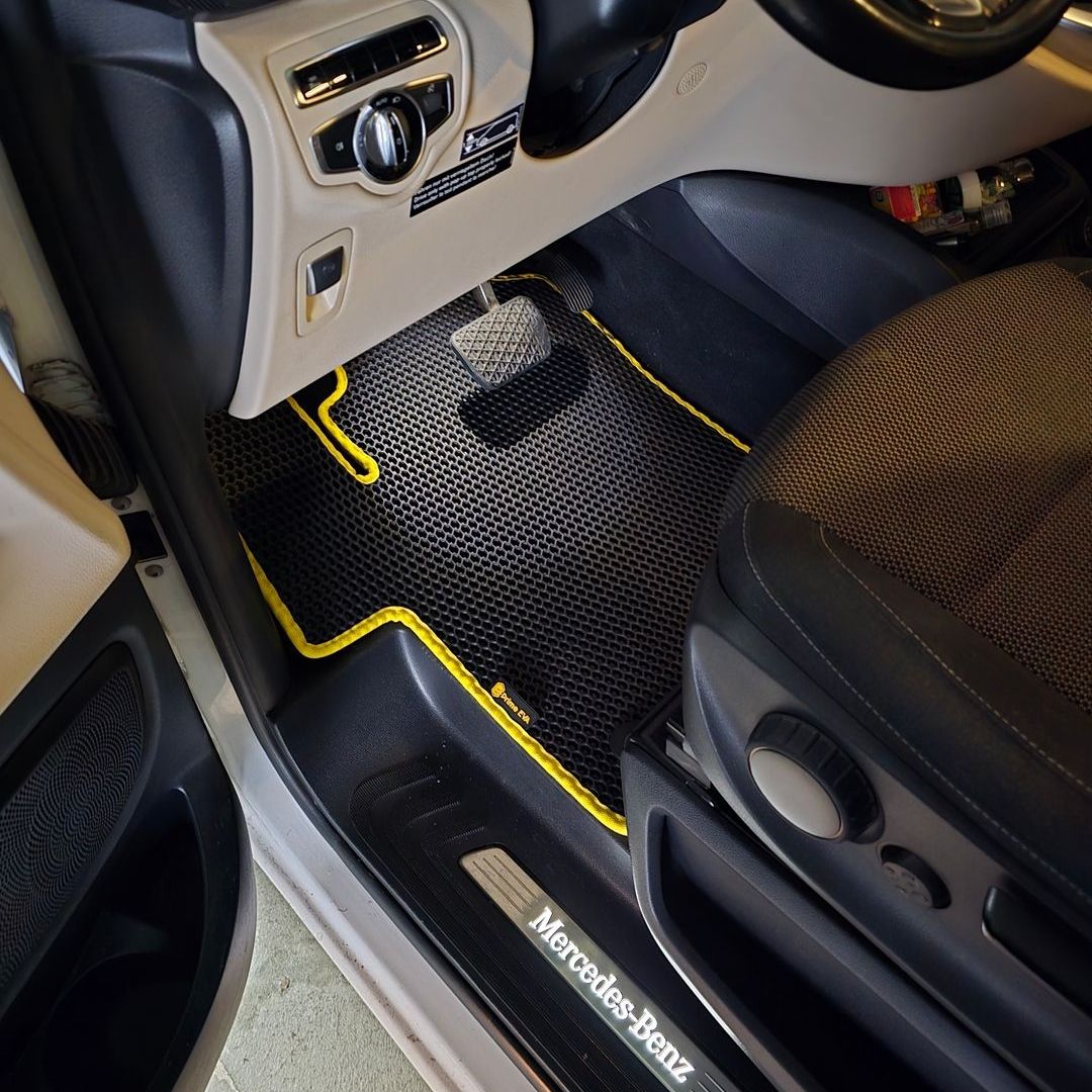 Black and yellow textured floor mat in a Mercedes-Benz van interior.