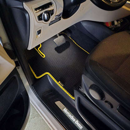 Black and yellow textured floor mat in a Mercedes-Benz van interior.