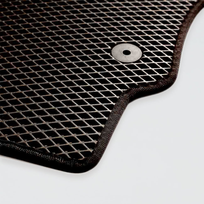 Textured black rubber car mat with a circular hole for attachment.