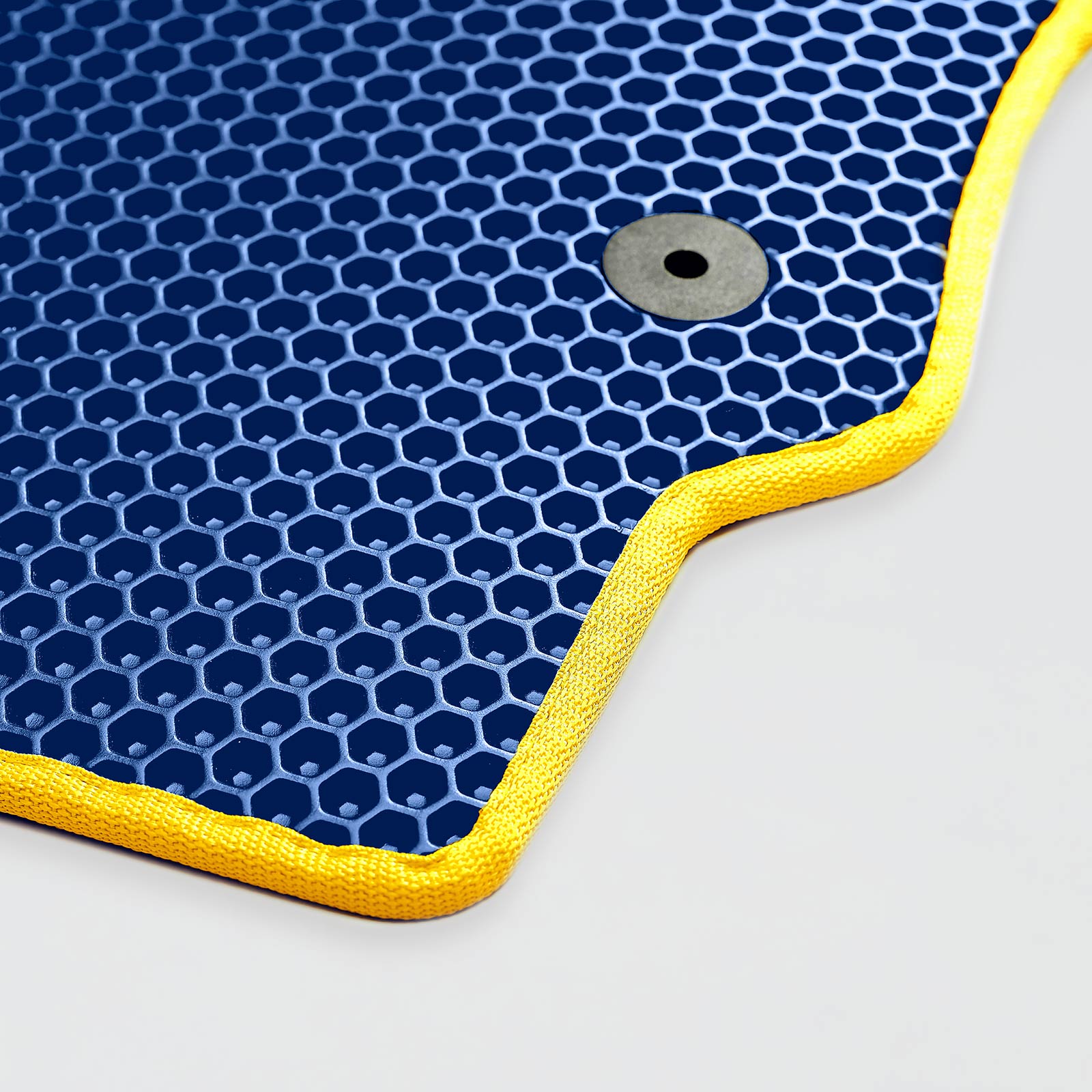 Navy blue textured mat with yellow edging and a metal grommet