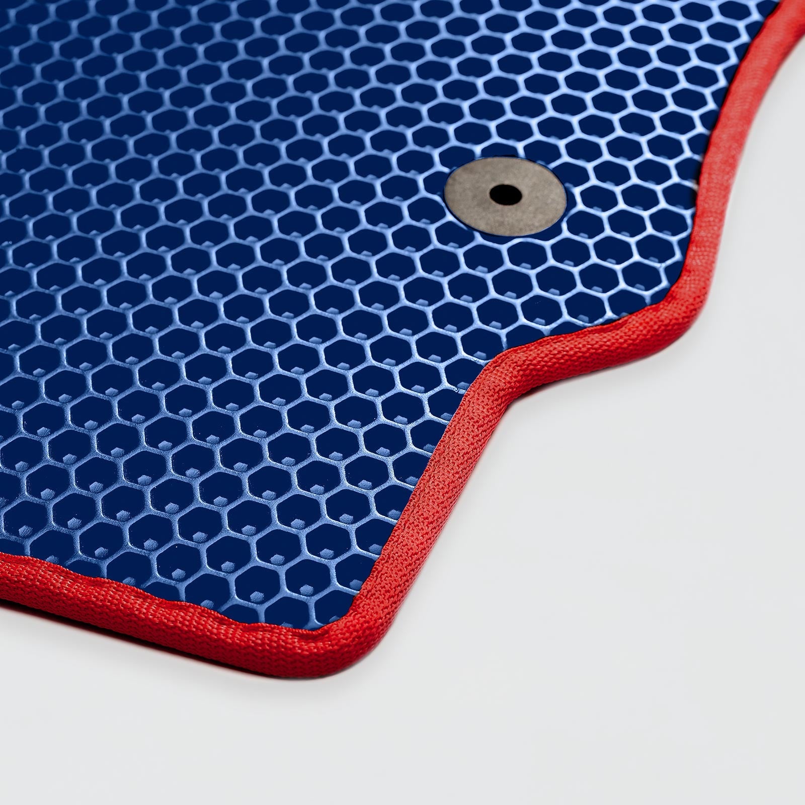 Blue hexagonal patterned mat with red border and a round hole for hanging
