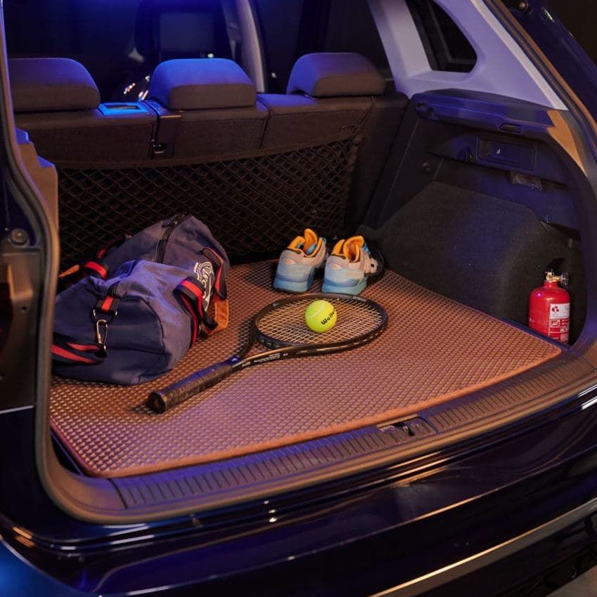 Brown textured trunk mat in an SUV, holding sports equipment and travel gear.