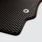 Black textured car mat with a round fastening hole in the corner.