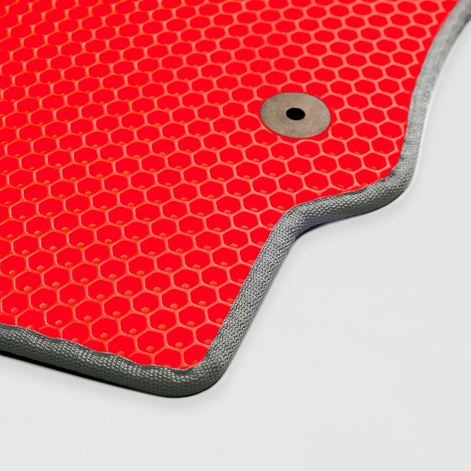 Bright red textured mat with a honeycomb pattern and a metallic circle